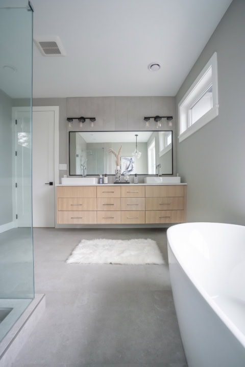 Custom home bathroom by White Wolf Homes in Victoria BC with modern dual vanity, freestanding tub, and glass shower.