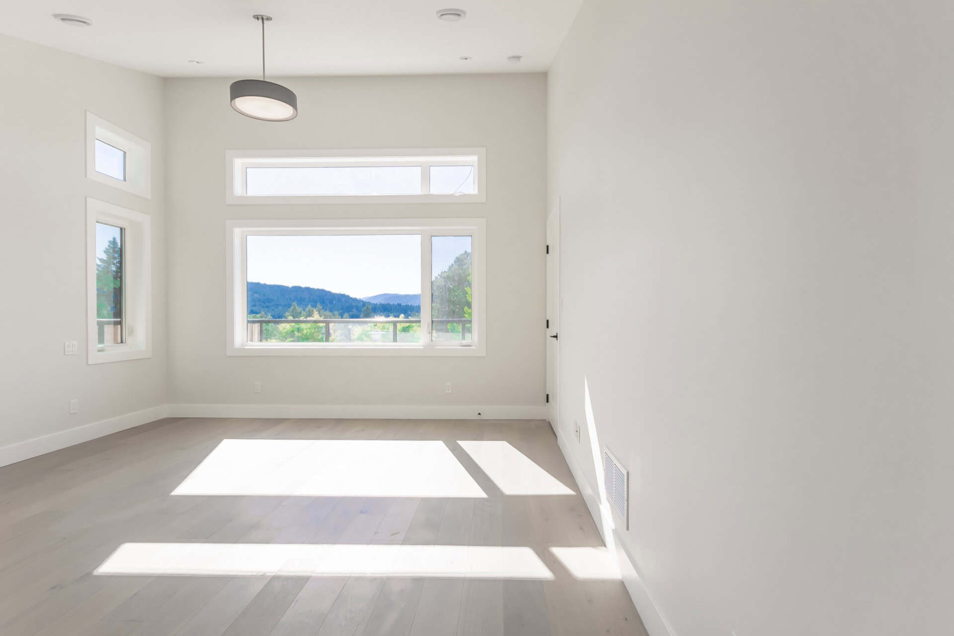 Bright empty living room with large windows and natural light.
