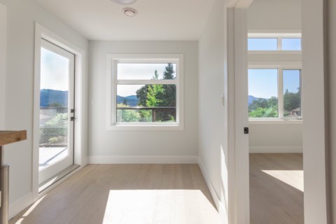 Bright empty room with large windows and natural light, modern interior in White Wolf Homes project.