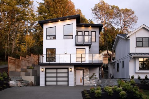 Modern two-story white home with large windows and black accents by Victoria BC builder.