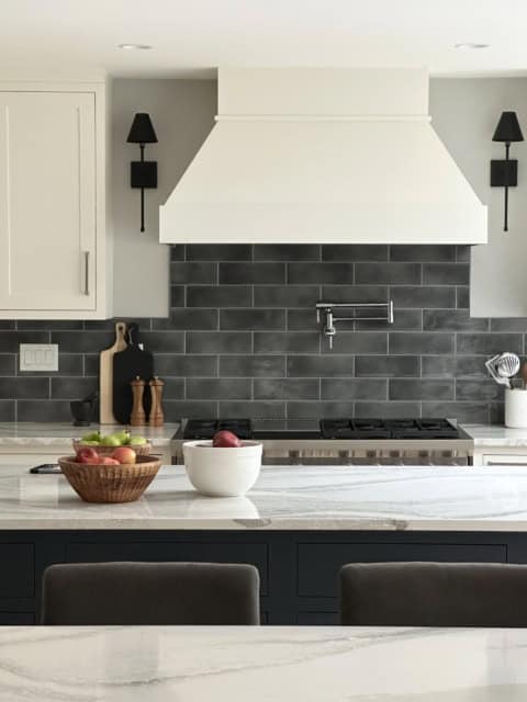 White Wolf Homes modern kitchen with gray hood and subway tile backsplash.