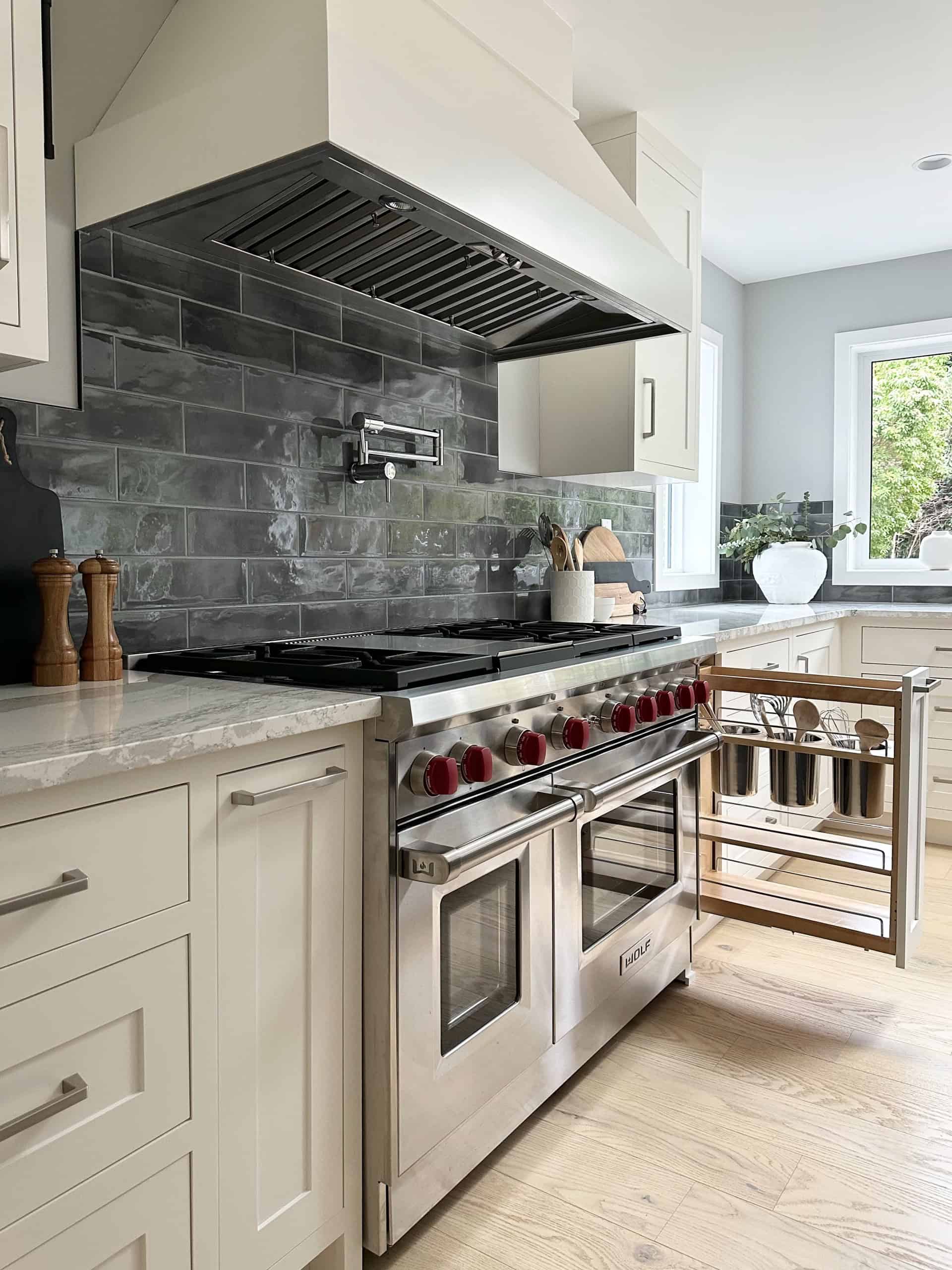 Modern kitchen with stainless steel range and white cabinets in a Victoria BC home.