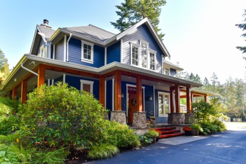Blue modern home with stone accents and front porch in Victoria BC.