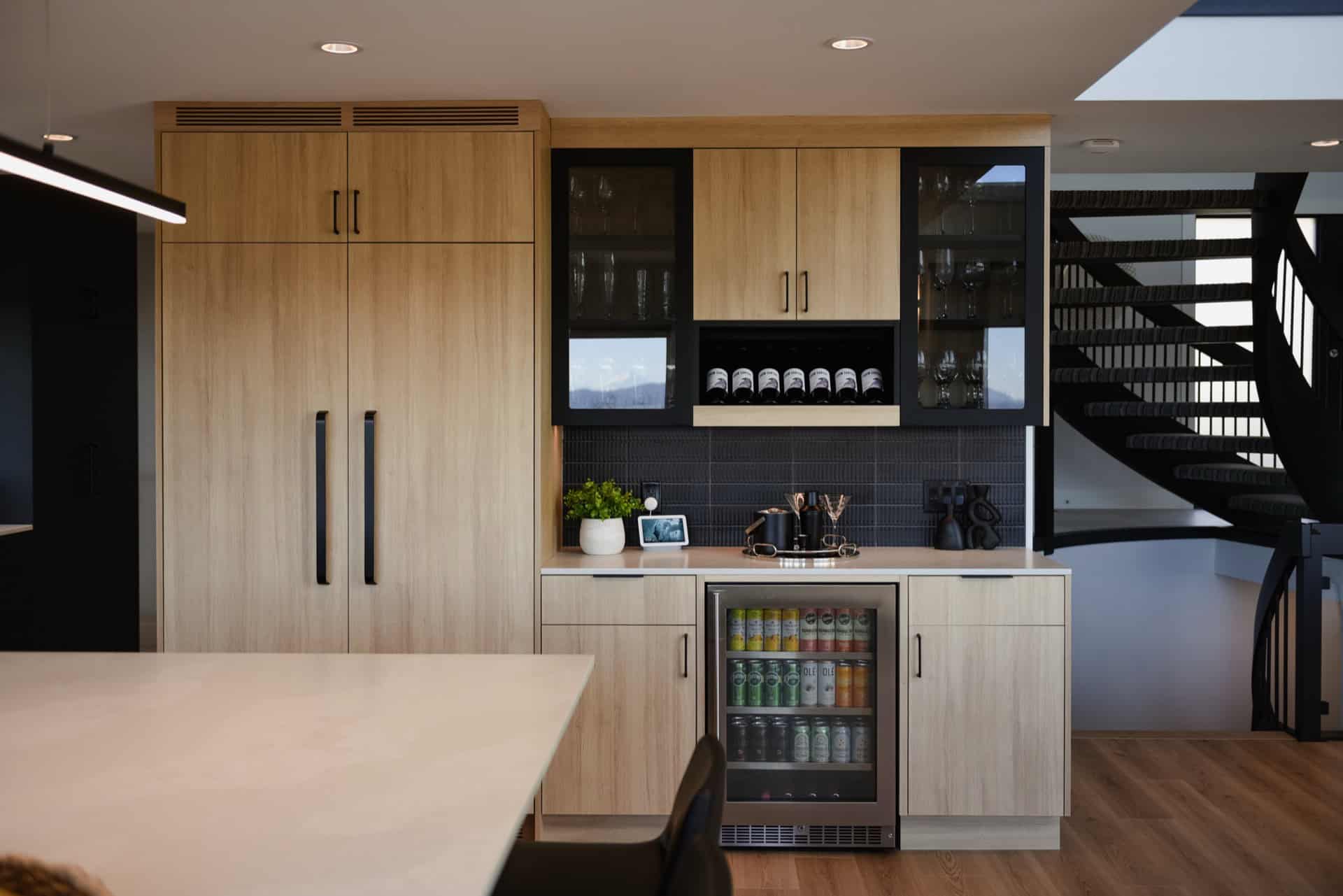 Modern kitchen in a Victoria BC home with light wood cabinetry and black accents.