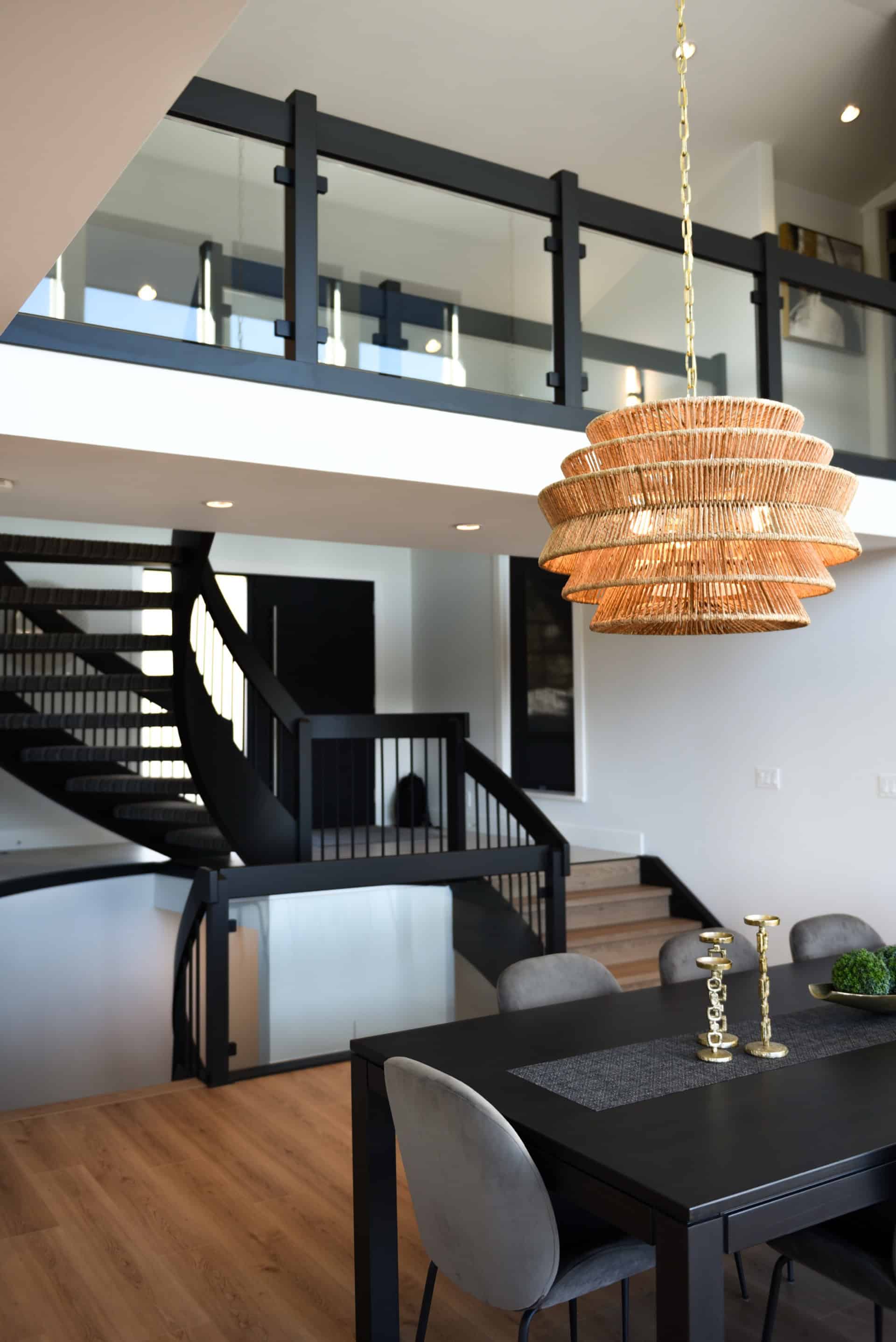 Modern interior of a Victoria BC custom home with open staircase and hanging woven light fixture.