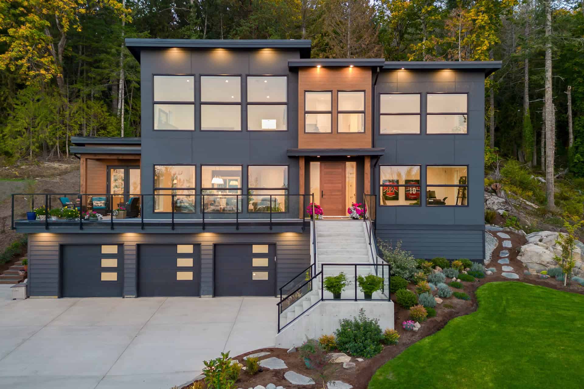 Modern custom home by White Wolf Homes in Victoria BC with dark gray exterior and large windows.