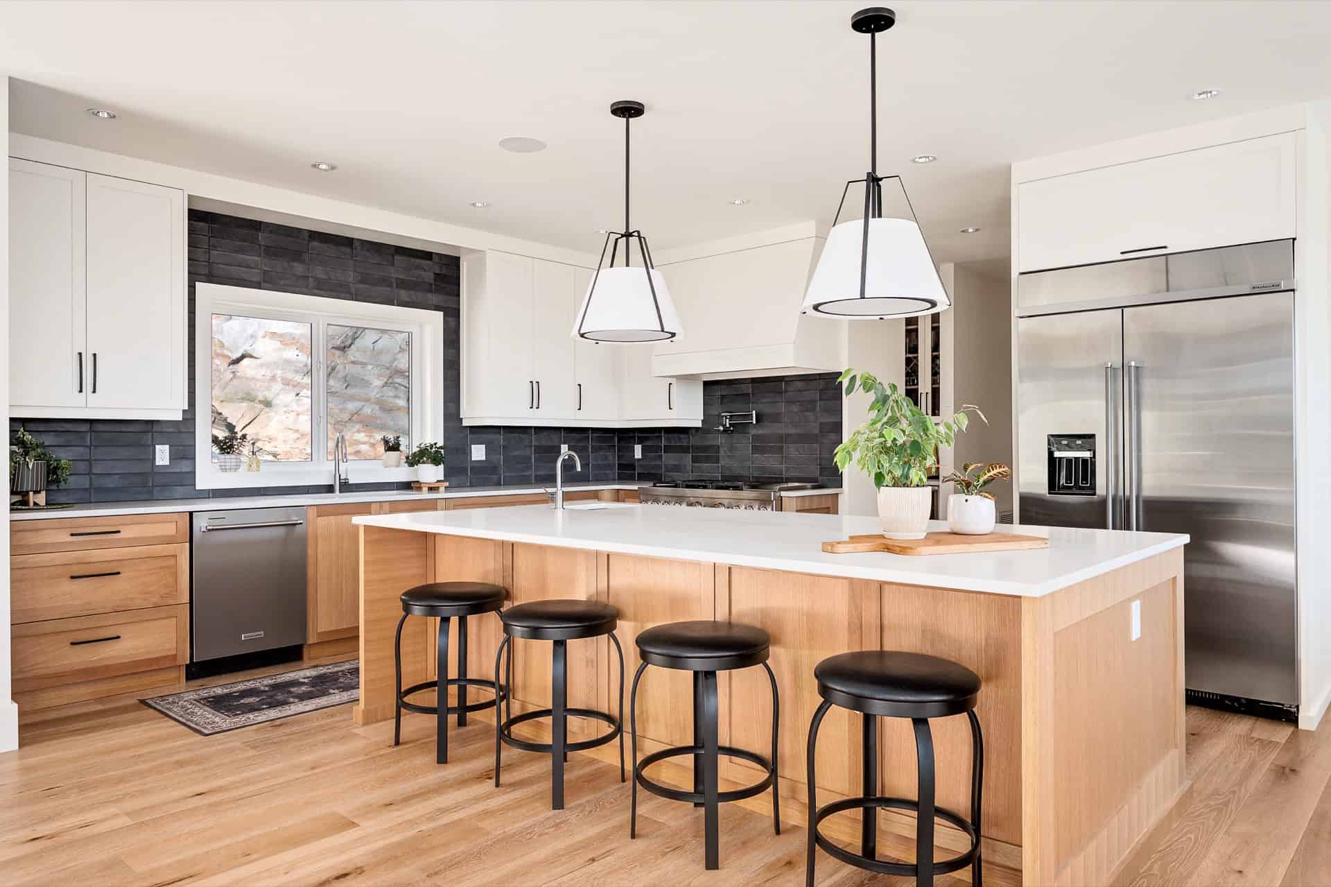 Modern white and wood kitchen with island and black bar stools in Victoria BC.