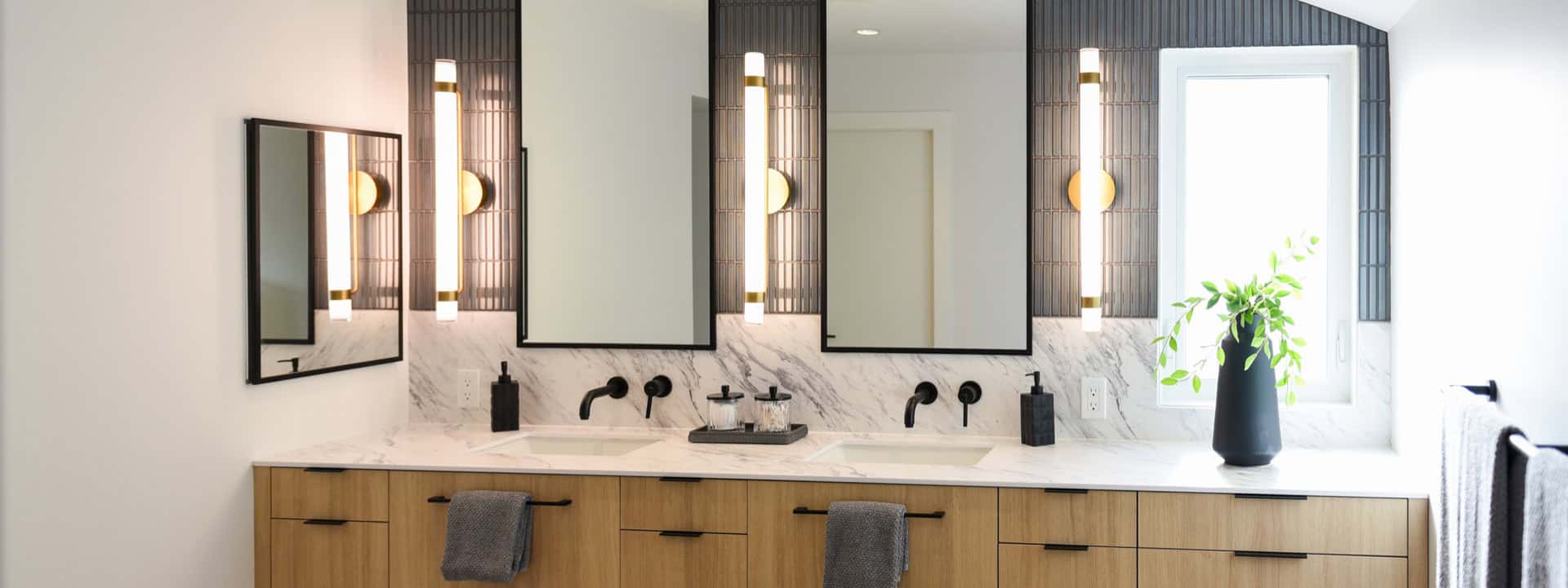 Modern master bathroom with double vanity, marble counters and large mirrors.