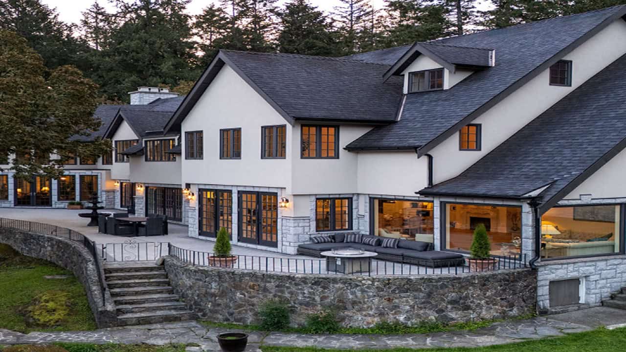 Victoria BC custom home exterior by White Wolf Homes with stonework and large windows.